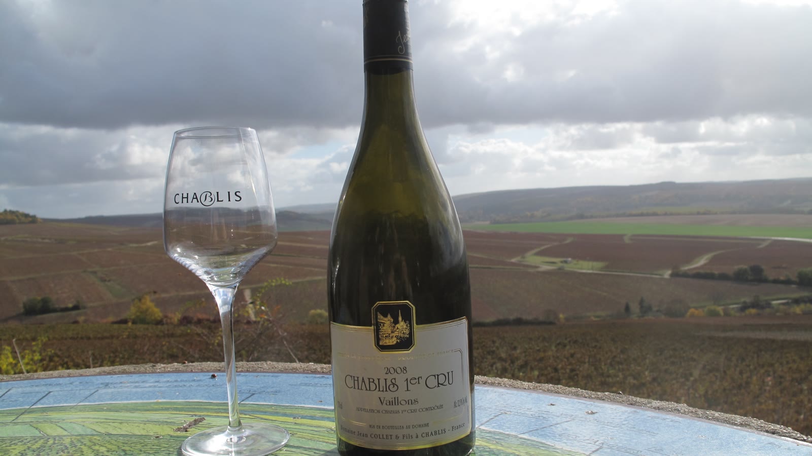 Flaske og glas chablis med udsigt over vinmarkerne