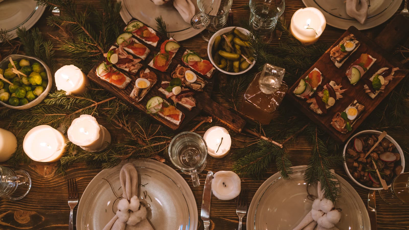 Dækket julebord set ovenfra med stearinlys og retter