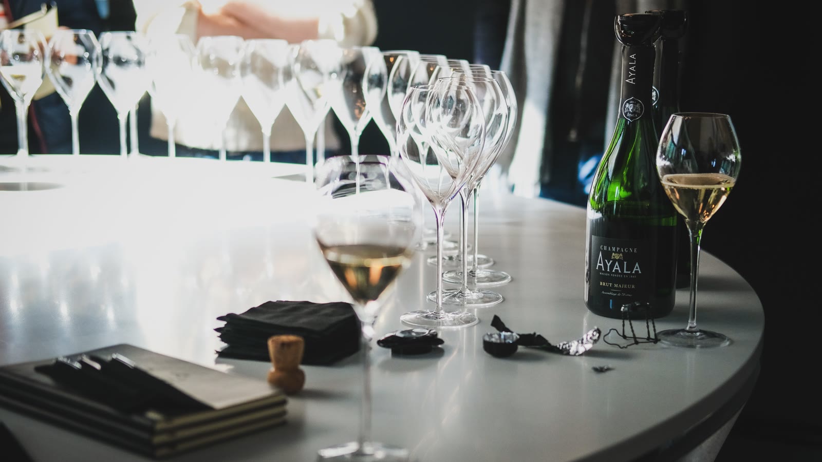 Glas og flaske mousserende vin på et bord