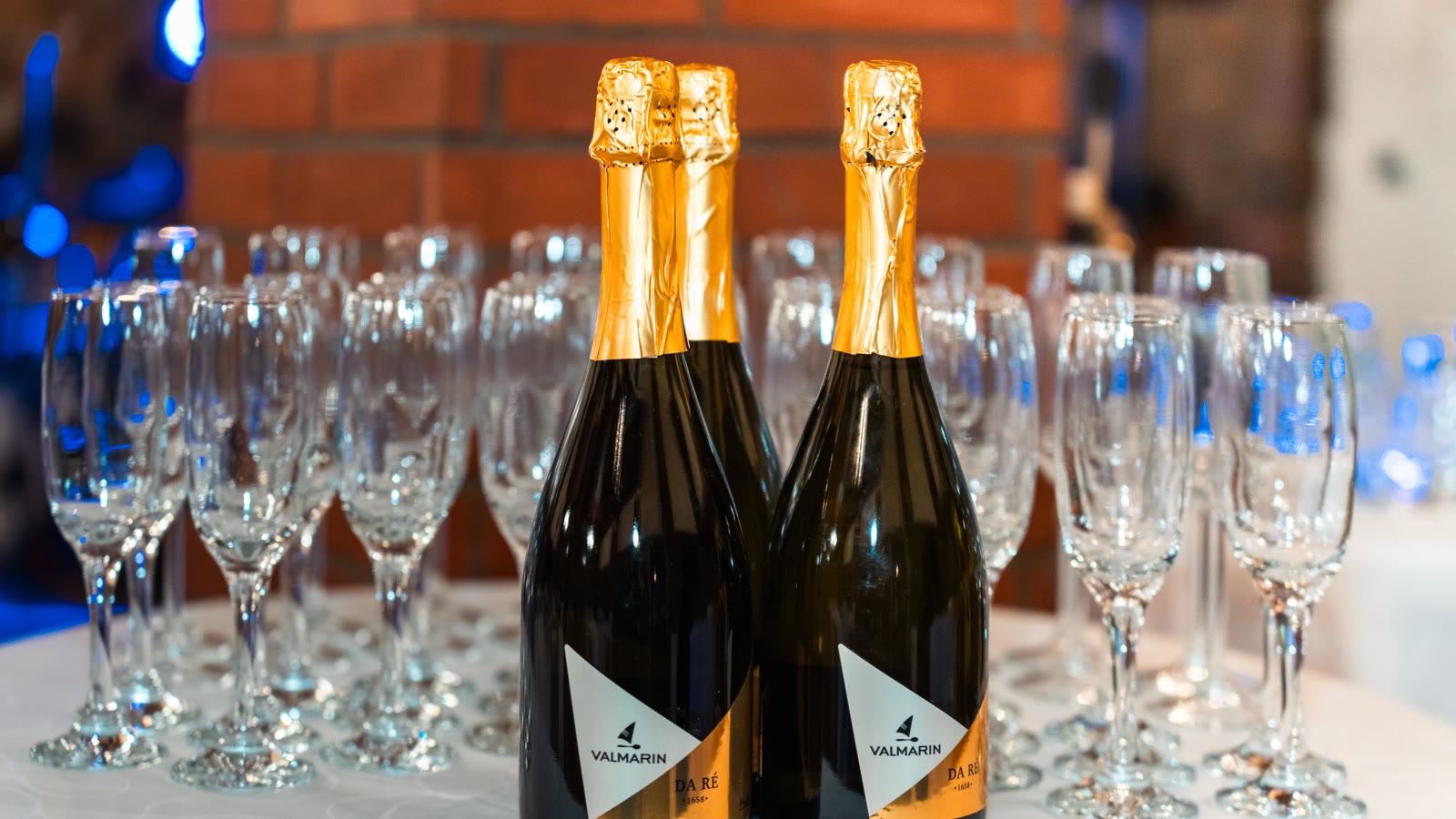 Champagneflasker og rækker af glas klar til skålen