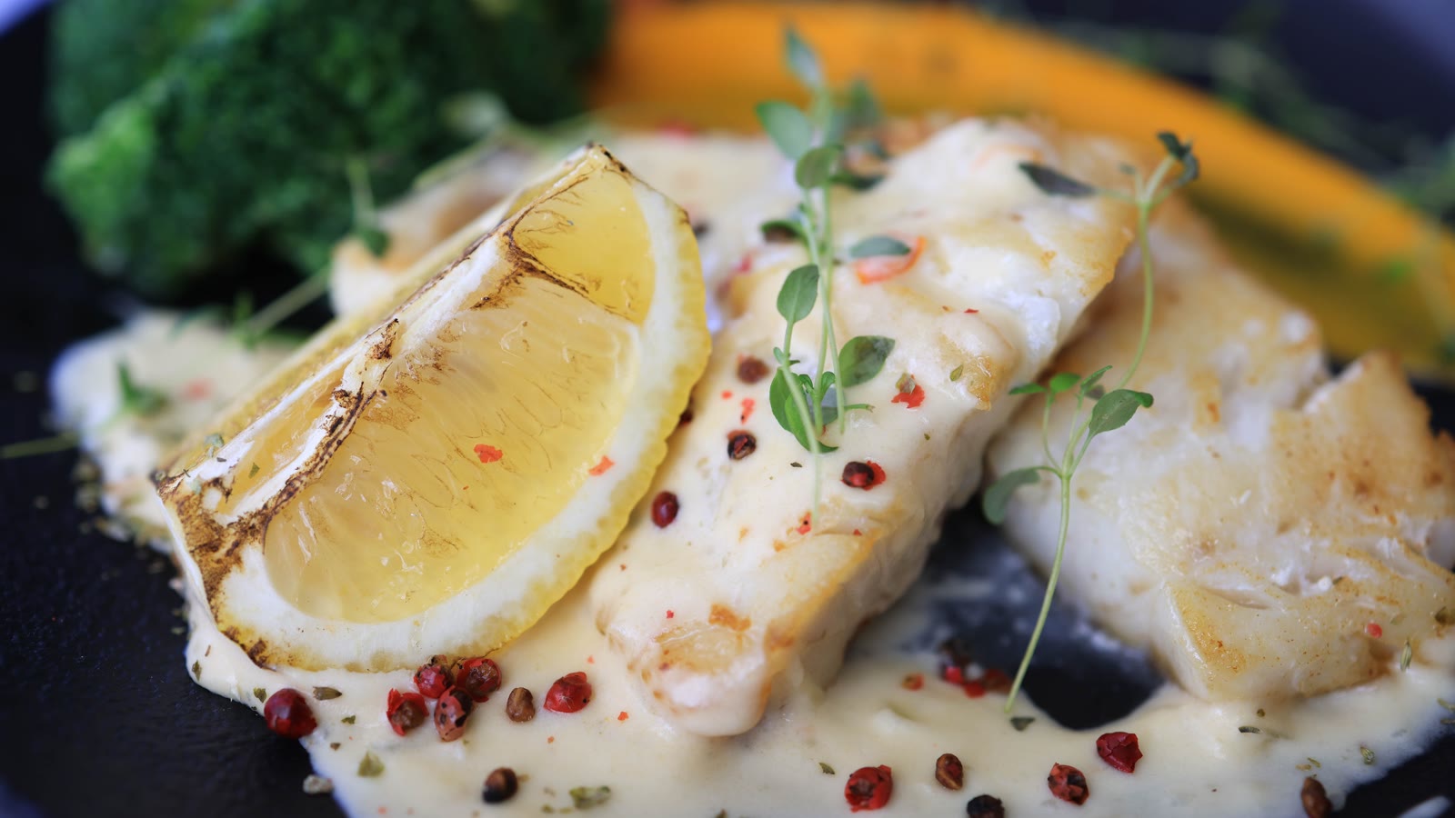 Hvid fisk med citron og cremet sauce på en tallerken