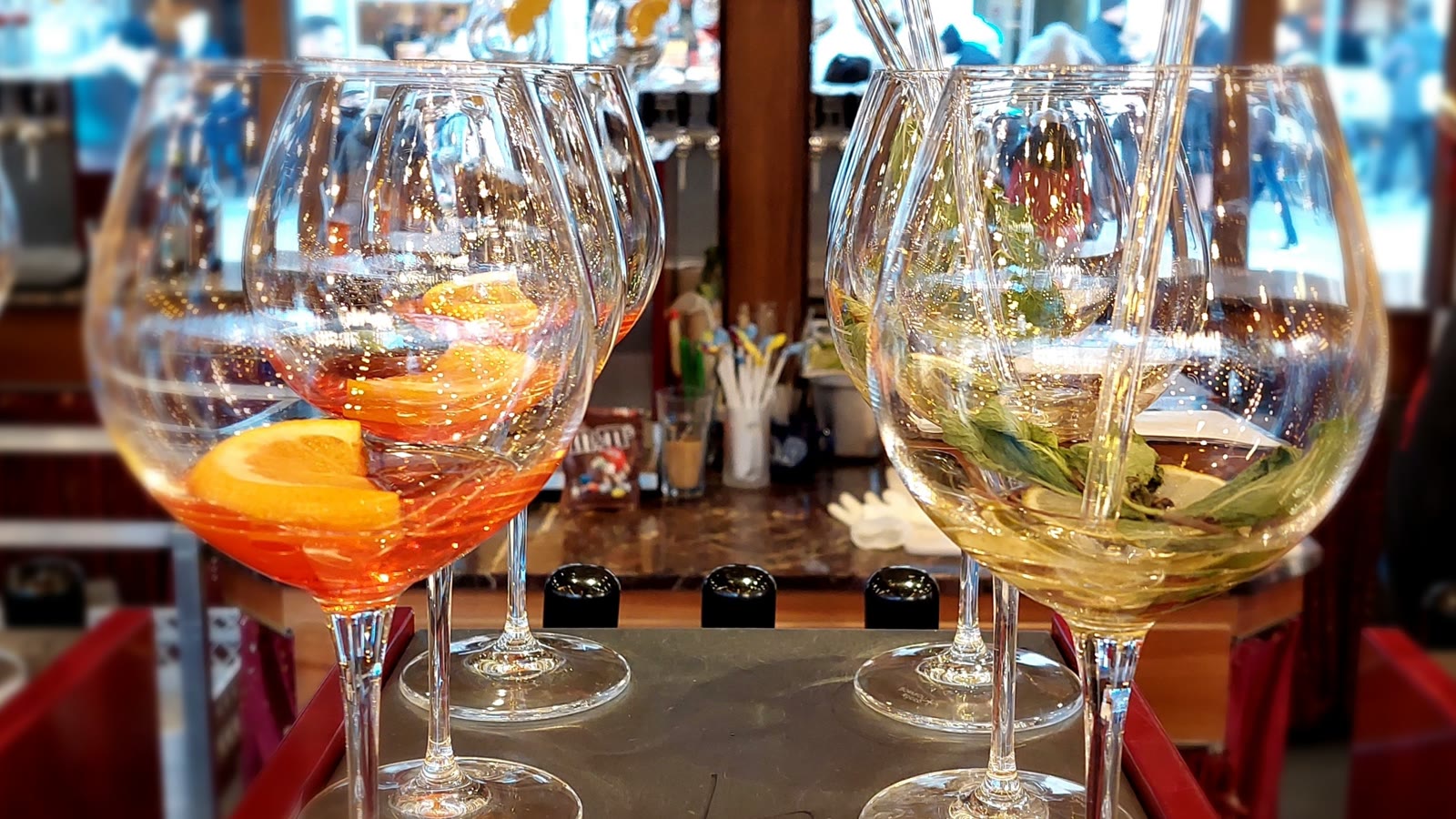 Række af store vinglas med spritz og hyldeblomstdrink klar på en bakke