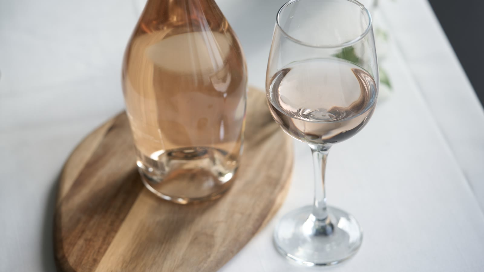Glas rosévin og en karaffel på et bord
